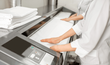 "Workers using automatic ironing machines for efficient and precise fabric ironing."