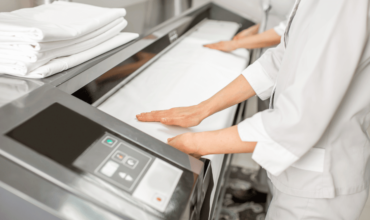 Hands operating an automatic ironing machine