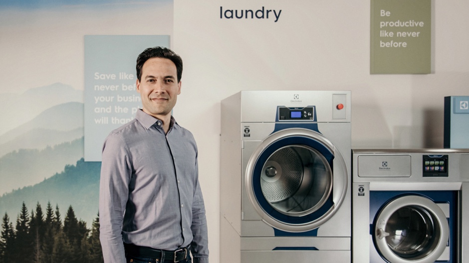 Man next to high-efficiency laundry machines