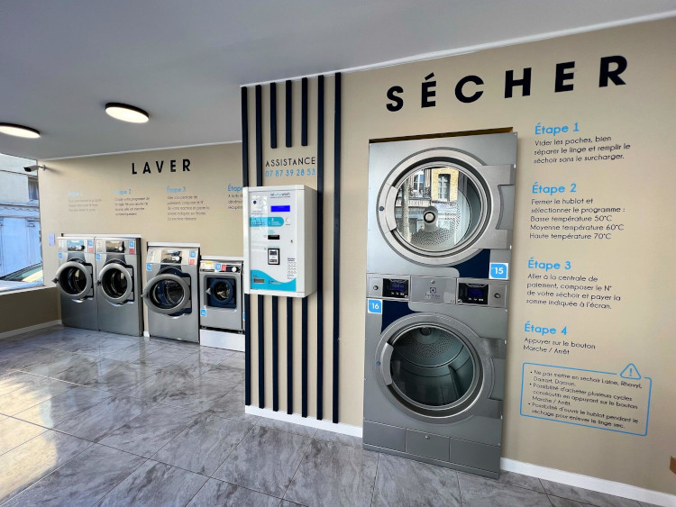 A functional laundry room showcasing a row of washing machines and dryers, designed for effective laundry management.